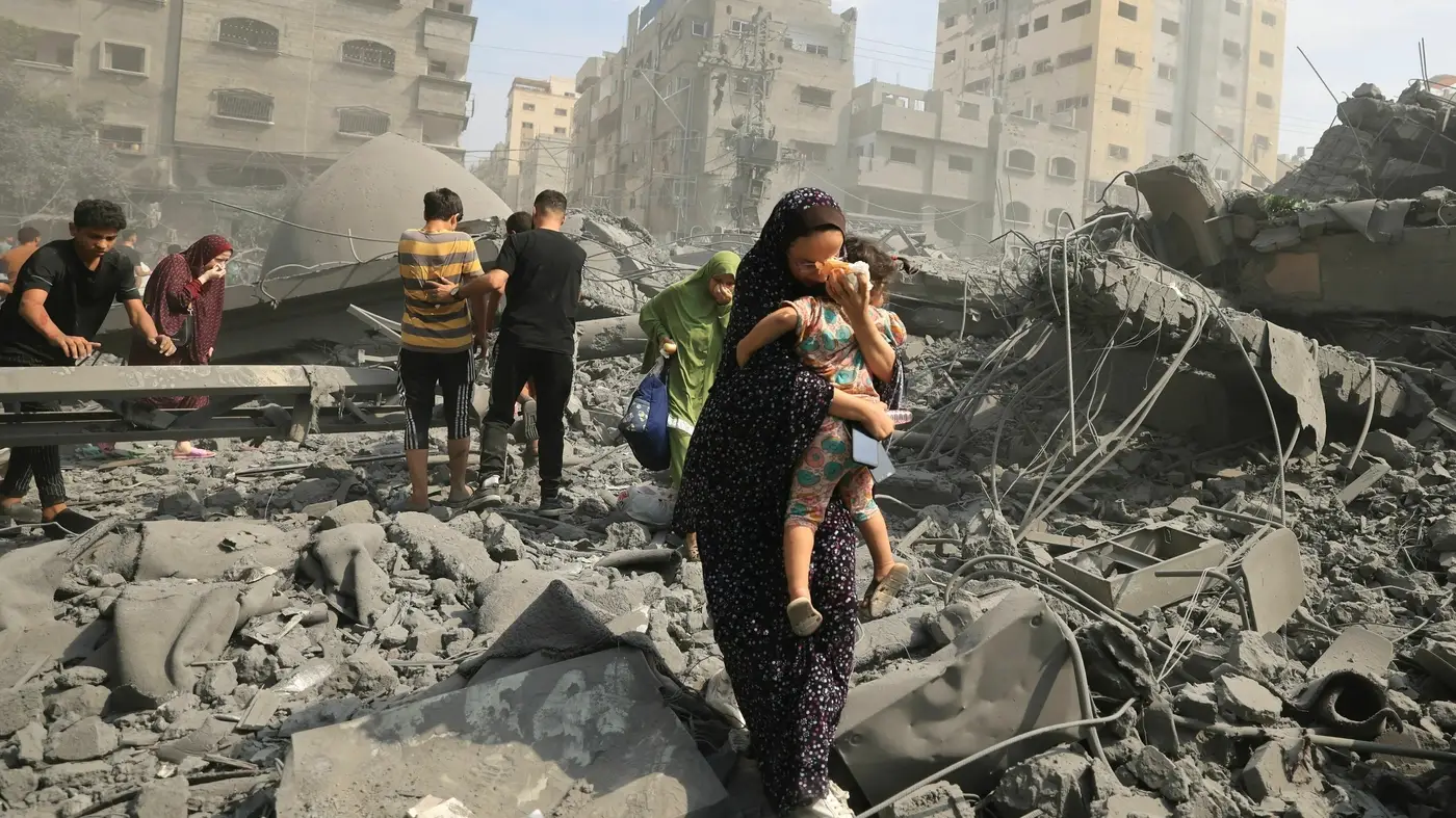TOPSHOT - Palestinians evacuate the area following an Israeli airstrike on the Sousi mosque in Gaza City on October 9, 2023. Israel continued to battle Hamas fighters on October 9 and massed tens of thousands of troops and heavy armour around the Gaza Strip after vowing a massive blow over the Palestinian militants' surprise attack. (Photo by Mahmud HAMS / AFP) (Photo by MAHMUD HAMS/AFP via Getty Images)